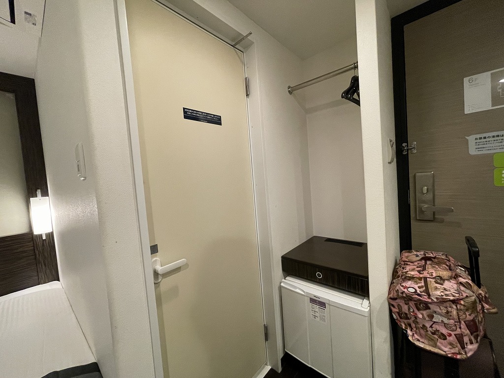 ホテルアクティブ！博多_621号室入り口横のユニットバス入り口、クローゼットスペース、セーフティボックス、冷蔵庫
